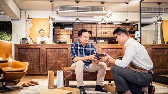 在全球供應鏈中養成「體面工作」的習慣 - 銷售人員在鞋店向顧客介紹新鞋
