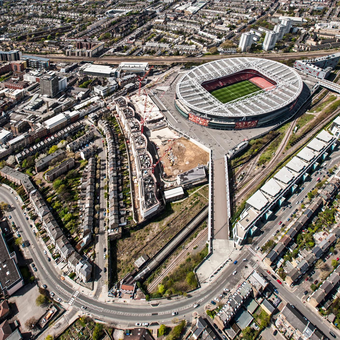 Aresenal Stadium from the air.  The scene portrays technology integration in modern engineering, airport safety management system and manufacturing in a complex setting.