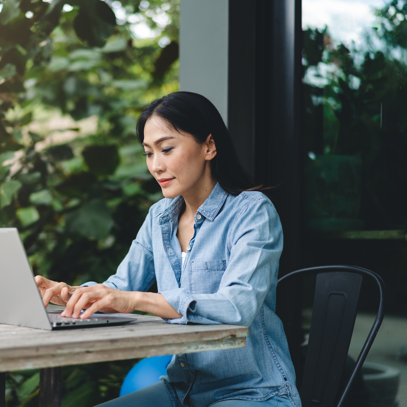 Happy female using laptop working outdoors, web conference, remote work concept.