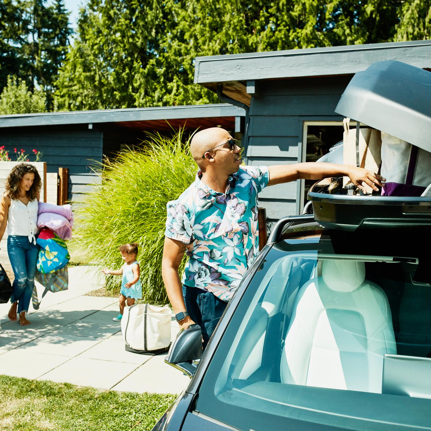 Famille chargeant les bagages dans le coffre de la voiture avant un roadtrip