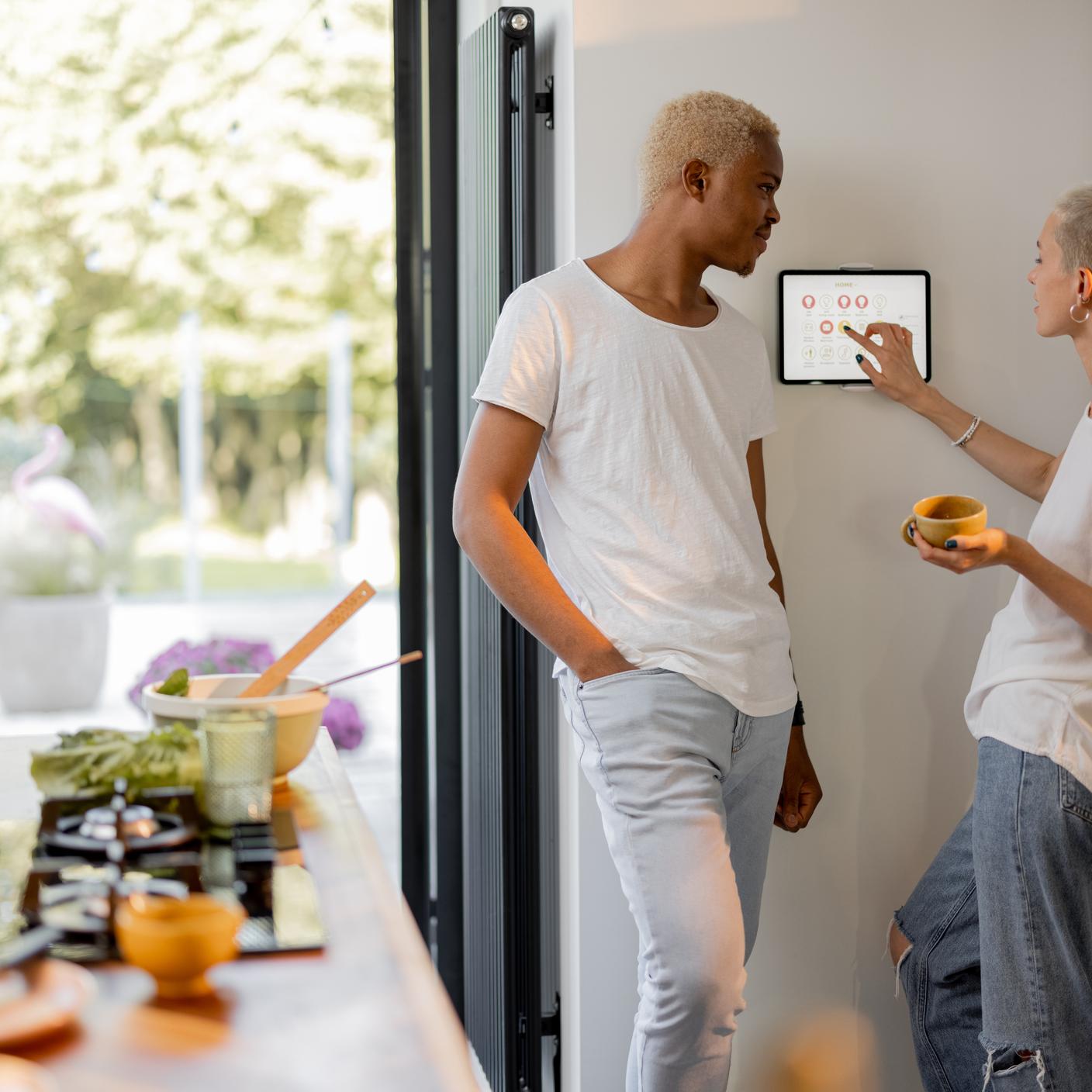 Pareja eligiendo la temperatura en el termostato mientras cocina