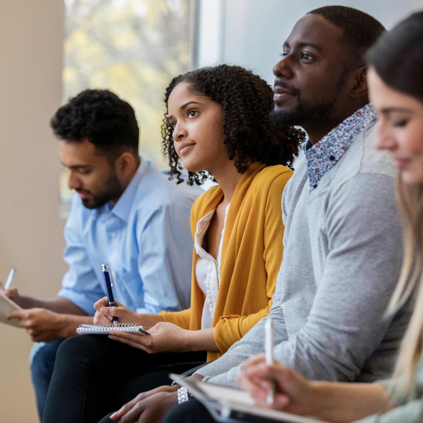 Empresarios sentados uno al lado del otro en una clase de capacitación.