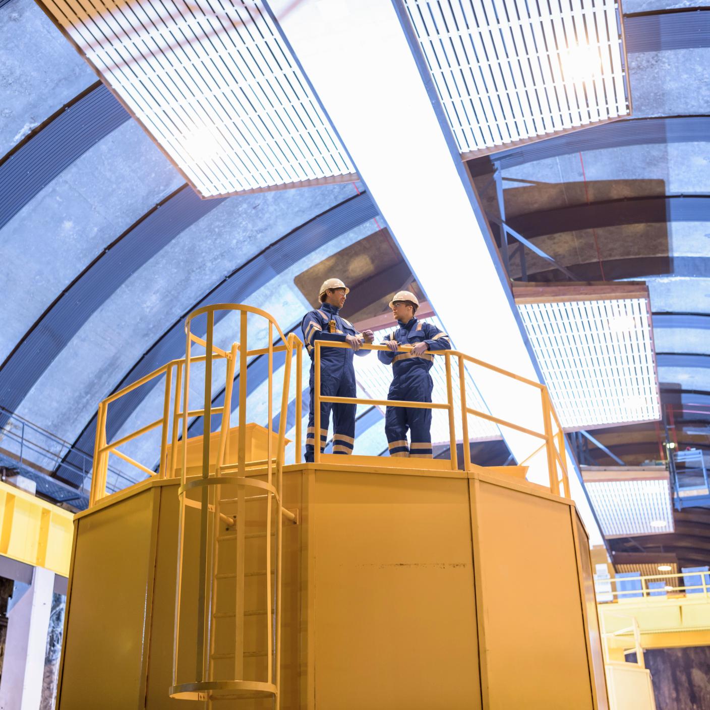 Workers having a discussion in generating hall in hydroelectric power station