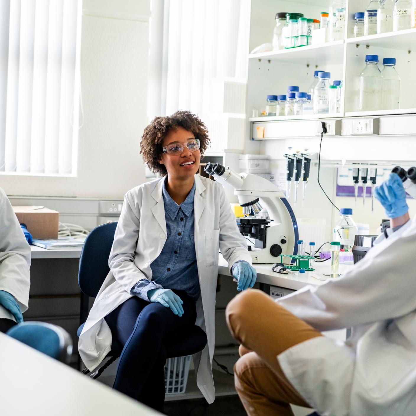 Young scientist discussing with colleagues. Male and female researchers are working together. 