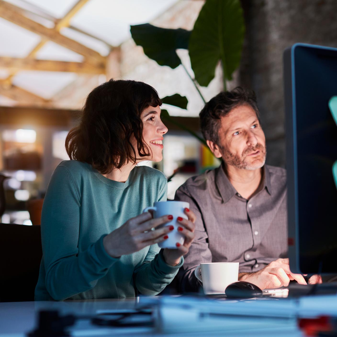 Ein Mann und eine Frau, die auf einen Laptop schauen