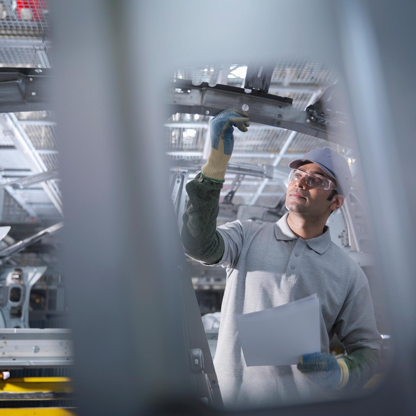Arbeiter in einer Autofabrik am Fließband