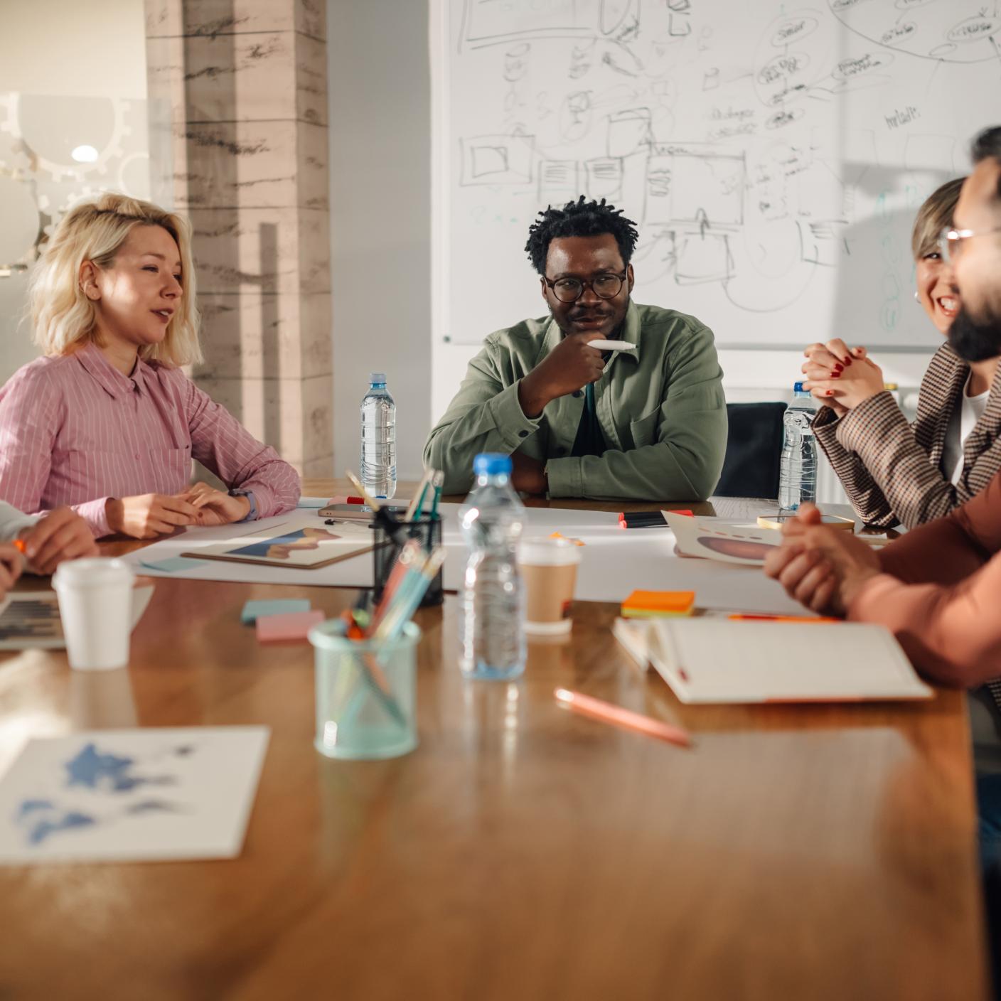 Marketing professionals are having a productive meeting, discussing project strategies and analyzing data, fostering teamwork and innovation in the workplace