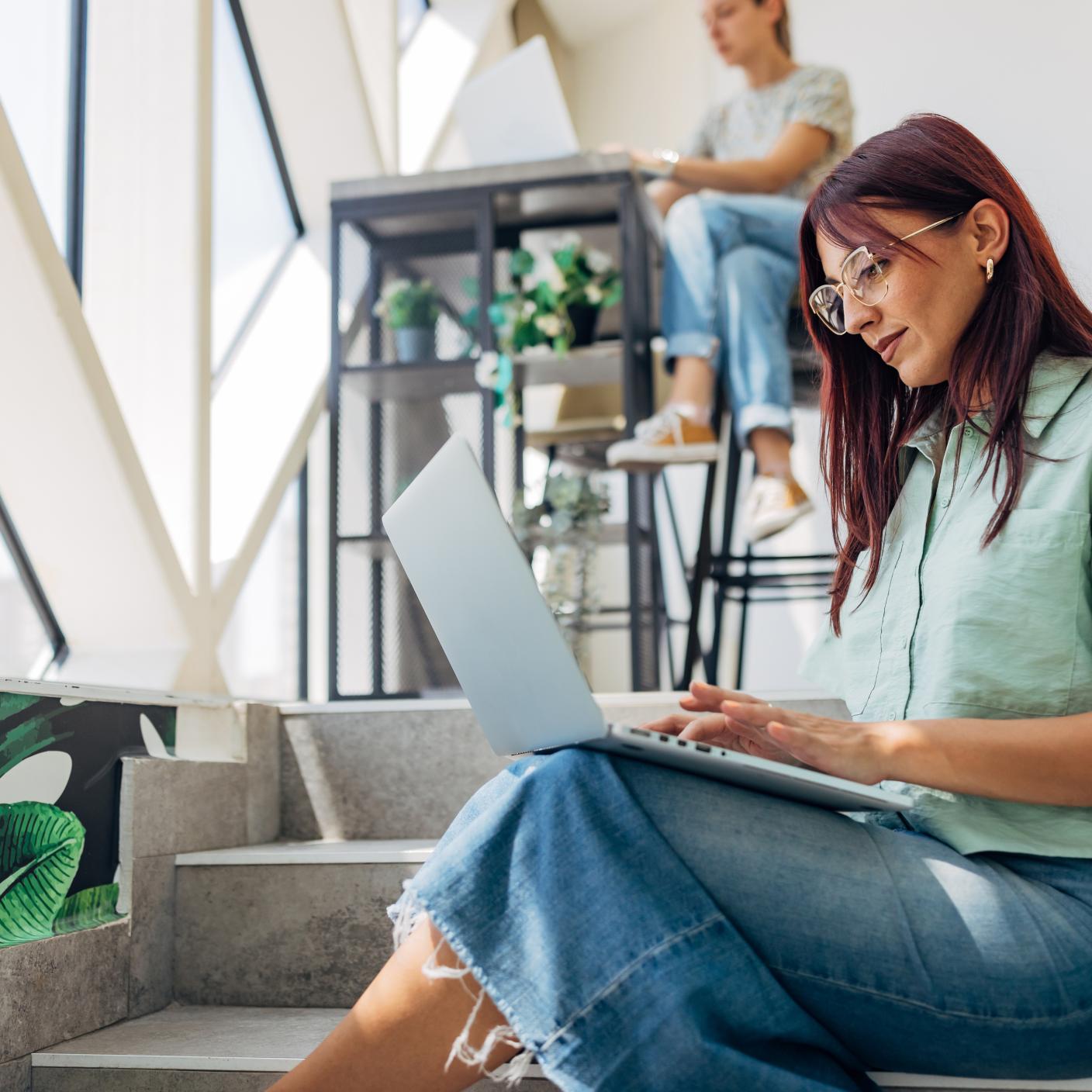 Happy female using laptop working outdoors, web conference, remote work concept.