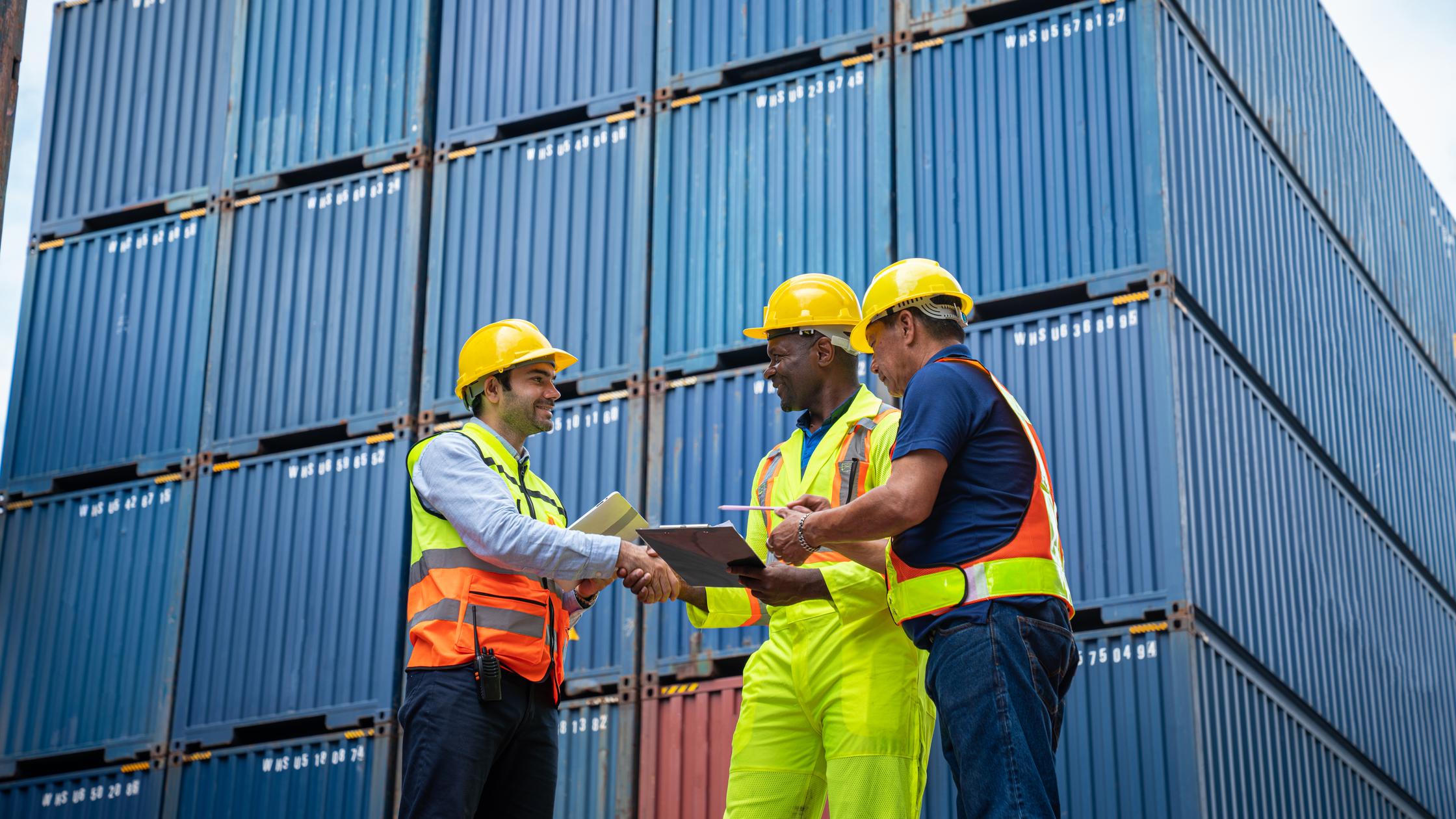 Ingeniero industrial masculino y capataz controlan la verificación de contenedores en el patio de contenedores del almacén. Negocio de logística. Concepto de importación y exportación.
